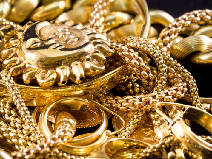 Image by Lapas77 via ShutterStock - Closeup of yellow gold jewelery on a black background