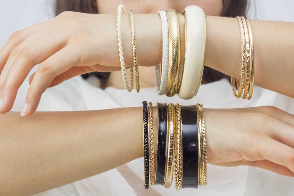 girls hand with golden bracelets - how to tell if gold is real